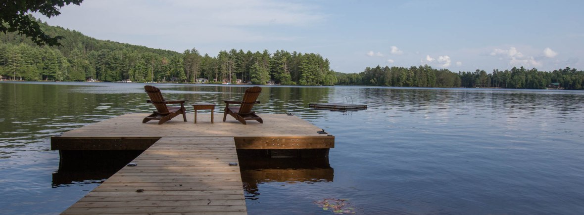 dock on lake with muskoka chairs